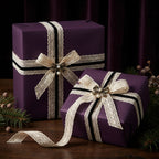 Elegant purple gift wrap with lace ribbon and pearl embellishment, perfect for Christmas or special occasions.