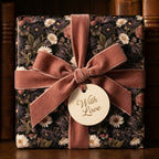Luxury floral wrapping paper with dusty rose velvet bow and 'With Love' gift tag by Wrapped Studios.