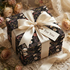 Vintage dark floral wrapping paper with cream satin ribbon and gift tag by Wrapped Studios.