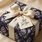 Luxury navy blue vintage floral wrapping paper with a cream bow and gift tag, by Wrapped Studios.