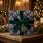 Luxury Christmas gift wrap with dark purple damask pattern and green velvet bow by Wrapped Studios.
