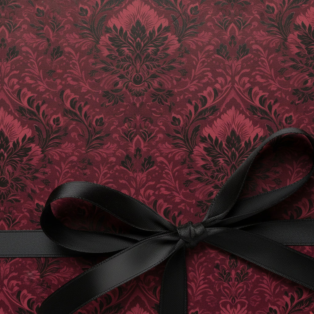 Burgundy floral wrapping paper on a gift box tied with a sleek black ribbon.