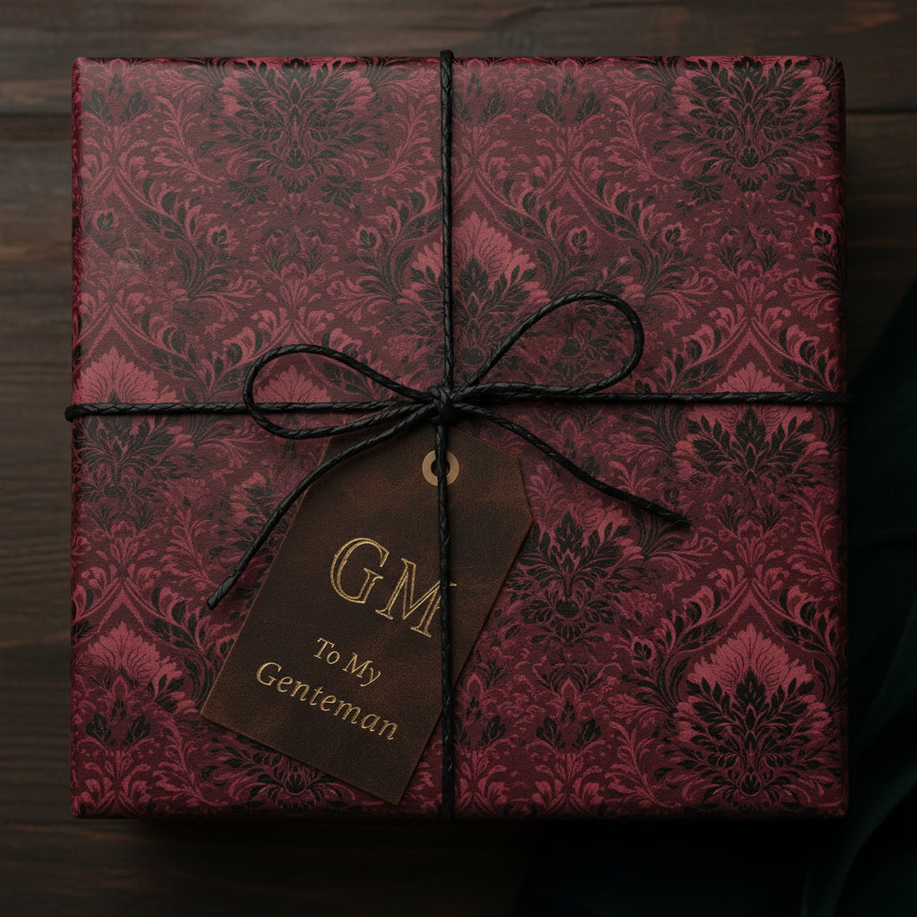 Burgundy damask wrapping paper on a gift box with leather tag for a gentleman.
