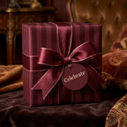 Burgundy striped luxury gift wrap by Wrapped Studios, featuring a matching satin bow and 'Celebrate' tag.