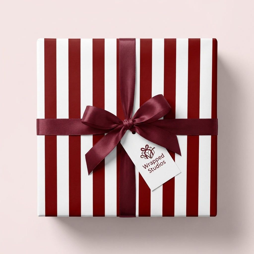Red and white striped Christmas gift wrap with a burgundy satin ribbon by Wrapped Studios.