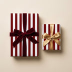 Red striped Christmas gift wrap with luxury velvet and gold bows by Wrapped Studios.