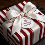 Red and white striped holiday wrapping paper with a luxury satin bow from Wrapped Studios.