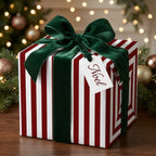 Red striped Christmas wrapping paper with a green velvet bow and Noel tag by Wrapped Studios.