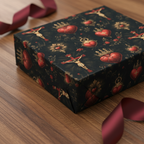 Elegant gift wrapped in dark floral wrapping paper with hearts and crosses, finished with burgundy ribbon.
