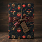 Elegant gift wrapped in vintage-style paper featuring hearts, crosses, and a burgundy ribbon with a "From the Heart" tag.
