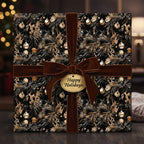 Elegant Christmas gift wrapped in floral black and gold paper with a velvet brown ribbon.