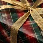 Red and green tartan plaid Christmas wrapping paper with a gold bow by Wrapped Studios.