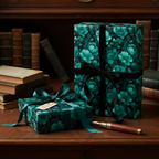 Elegant gift boxes wrapped in teal floral wrapping paper with black and teal ribbons on a wood desk.