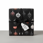 Luxury black Christmas wrapping paper with elegant ornament pattern and black ribbon, perfect for holiday gifts.