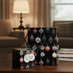 Elegant black Christmas wrapping paper with festive red, silver, and white ornament patterns, tied with a baker's twine bow and "A Special Pair" gift tag on a wooden table.