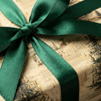 Vintage-style Christmas wrapping paper with green satin ribbon. From Wrapped Studios.