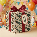 Dinosaur birthday wrapping paper with burgundy ribbon, tag reads "Congratulations, Dino-mite!"