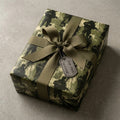 Military camouflage wrapping paper with olive ribbon and "For Your Service" dog tag by Wrapped Studios.