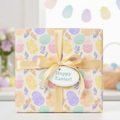 Pastel Easter egg wrapping paper with gold ribbon and "Happy Easter!" gift tag.