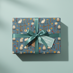 Easter gift wrapped in blue paper with a bunny, cross, and floral pattern, finished with a satin ribbon.