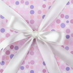 Lilac polka dot wrapping paper with a tied white satin ribbon; perfect birthday wrapping paper.