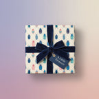 Square gift box wrapped in beetle-patterned wrapping paper with a navy velvet ribbon and "A Little Treasure" gift tag.