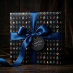 Elegant gift wrapped in beetle print wrapping paper with a blue satin ribbon and a gift tag.