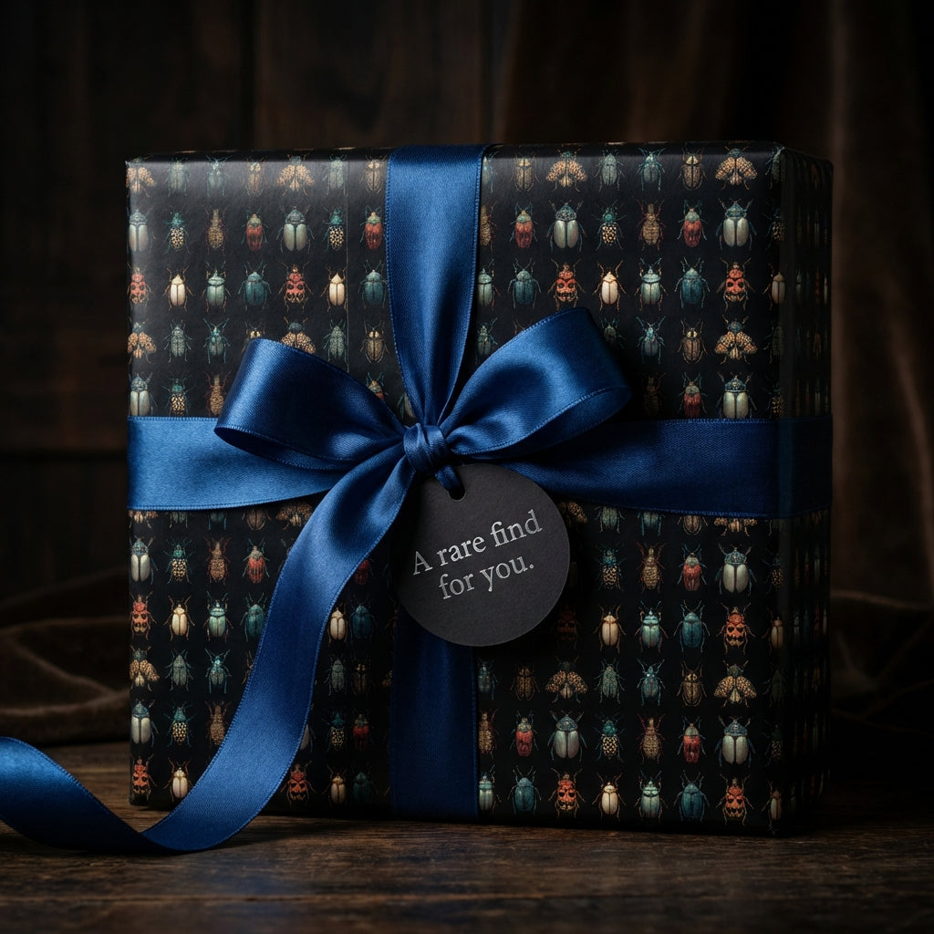 Elegant gift wrapped in beetle print wrapping paper with a blue satin ribbon and a gift tag.