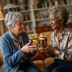 Women exchanging a gift wrapped in elegant floral birthday wrapping paper with a gold ribbon.