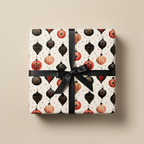 Festive Christmas wrapping paper with vintage-style red, black, and gold ornament pattern, tied with a black satin bow on a neutral background.