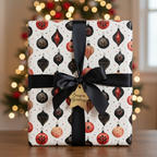 Elegant Christmas wrapping paper featuring black and red vintage ornament patterns, tied with a black satin ribbon and gold "Season's Greetings" tag.