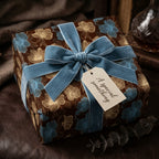 Elegant brown floral wrapping paper with blue velvet ribbon and gift tag.