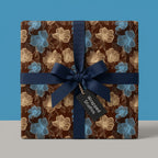 Wrapped Studios floral wrapping paper. Gift box with navy bow on dark brown background.