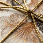 Elegant ginkgo leaf luxury wrapping paper tied with gold metallic cord, by Wrapped Studios.