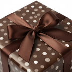 Brown polka dot wrapping paper with a classic chocolate brown satin bow, ideal for elegant birthday or special occasion gifts.