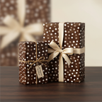 Elegant brown polka dot wrapping paper with champagne ribbon and twine, perfect for luxury birthday or holiday gifts.