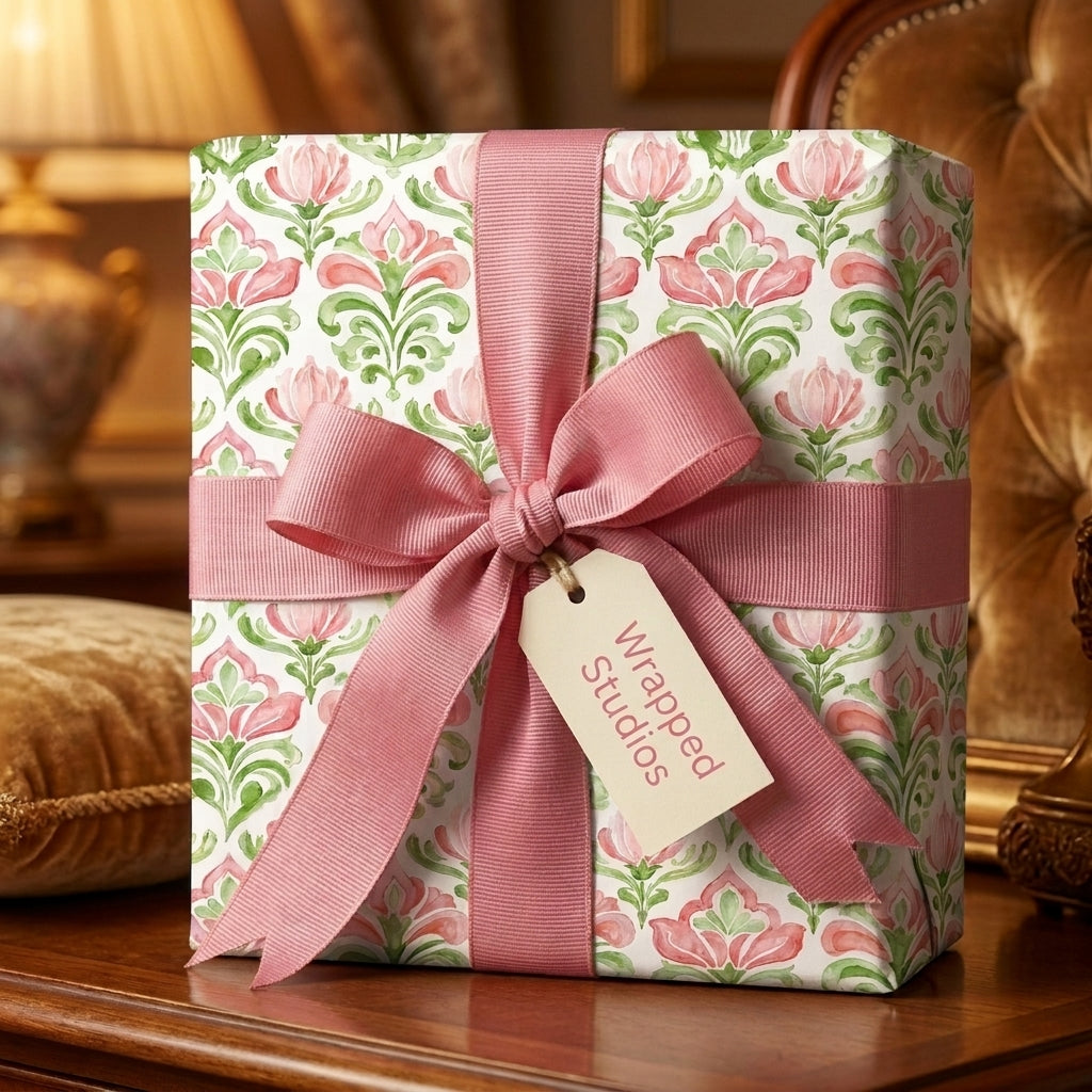 Elegant pink floral wrapping paper by Wrapped Studios on a gift box with a dusty pink ribbon bow.
