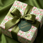 Elegant pink floral wrapping paper with olive green satin bow and gift tag, by Wrapped Studios.