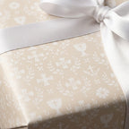 Beige baptism wrapping paper with white crosses, chalices, and a satin ribbon by Wrapped Studios.