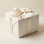 Elegant cream baptism wrapping paper with crosses and satin bow on a gift box by Wrapped Studios.