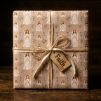 First Communion wrapping paper featuring praying girls, tied with a rustic Faith tag by Wrapped Studios.