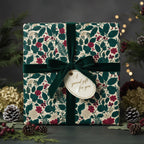 Elegant floral wrapping paper with dark green velvet ribbon and gift tag, perfect for Christmas gifts.