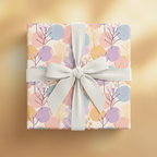 Gift box wrapped in pastel floral wrapping paper with an elegant white bow.