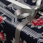 Luxury floral wrapping paper with red roses and tech circuits, tied with a silver bow by Wrapped Studios.