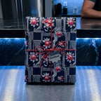 Floral circuit board wrapping paper with red roses on a gift box with a red twine bow by Wrapped Studios.