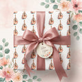 Watercolor floral guitar wrapping paper with a dusty rose satin ribbon and gift tag by Wrapped Studios.