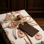 Acoustic guitar wrapping paper by Wrapped Studios, featuring floral music patterns and a rustic twine bow.