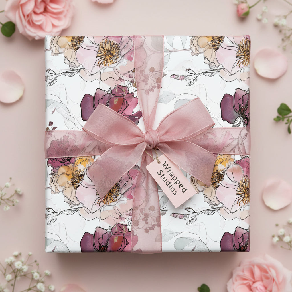 Elegant floral wrapping paper on a gift box with a pink sheer ribbon and roses.