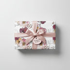 Elegant gift wrapped in modern floral wrapping paper with a blush satin ribbon and bow.