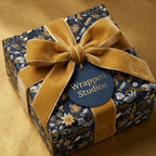 Wrapped Studios luxury gift wrap. Floral wrapping paper with gold velvet ribbon and navy tag.